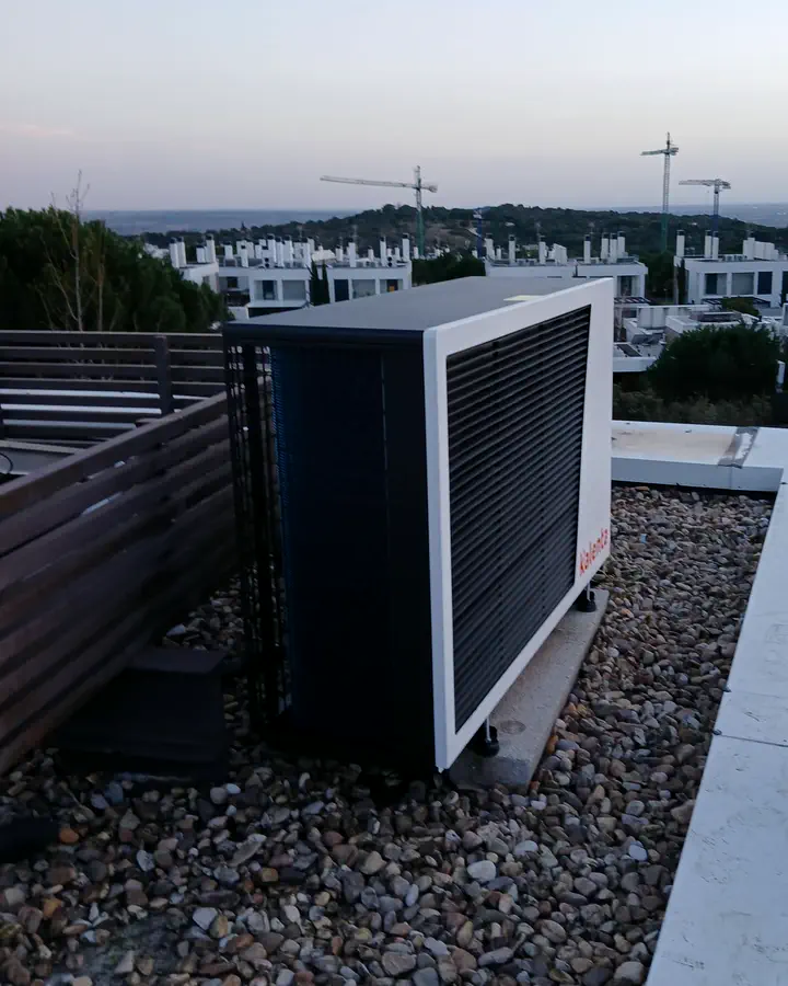Unidad exterior de aerotermia en una terraza de grava con vistas a la Sierra. Instalación de Guzmán Calefacción